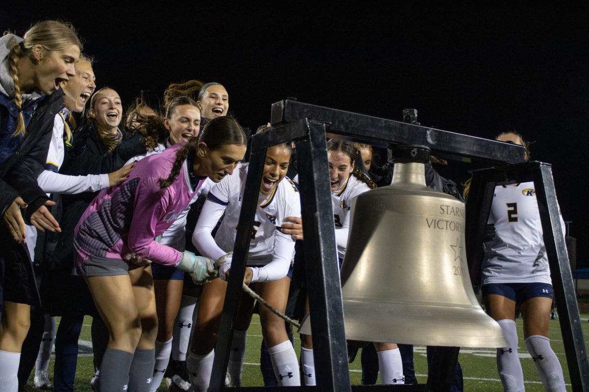 Kent junior forward Josie Morgan (25) and junior goalkeeper Leah Shaffer (1) ring the victory bell after winning their game against Toledo on Thursday, Oct. 23, 2025. Their win gave them a spot in the MAC Tournament Championship.