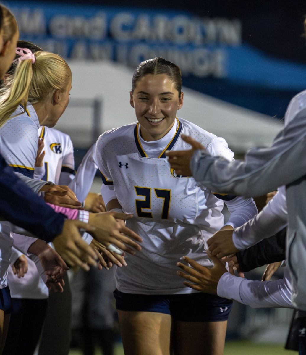 Kent freshman Mia Cleroux runs through the tunnel as her teammates high five her before the start of their game against Toledo on Thursday, Oct. 23, 2025