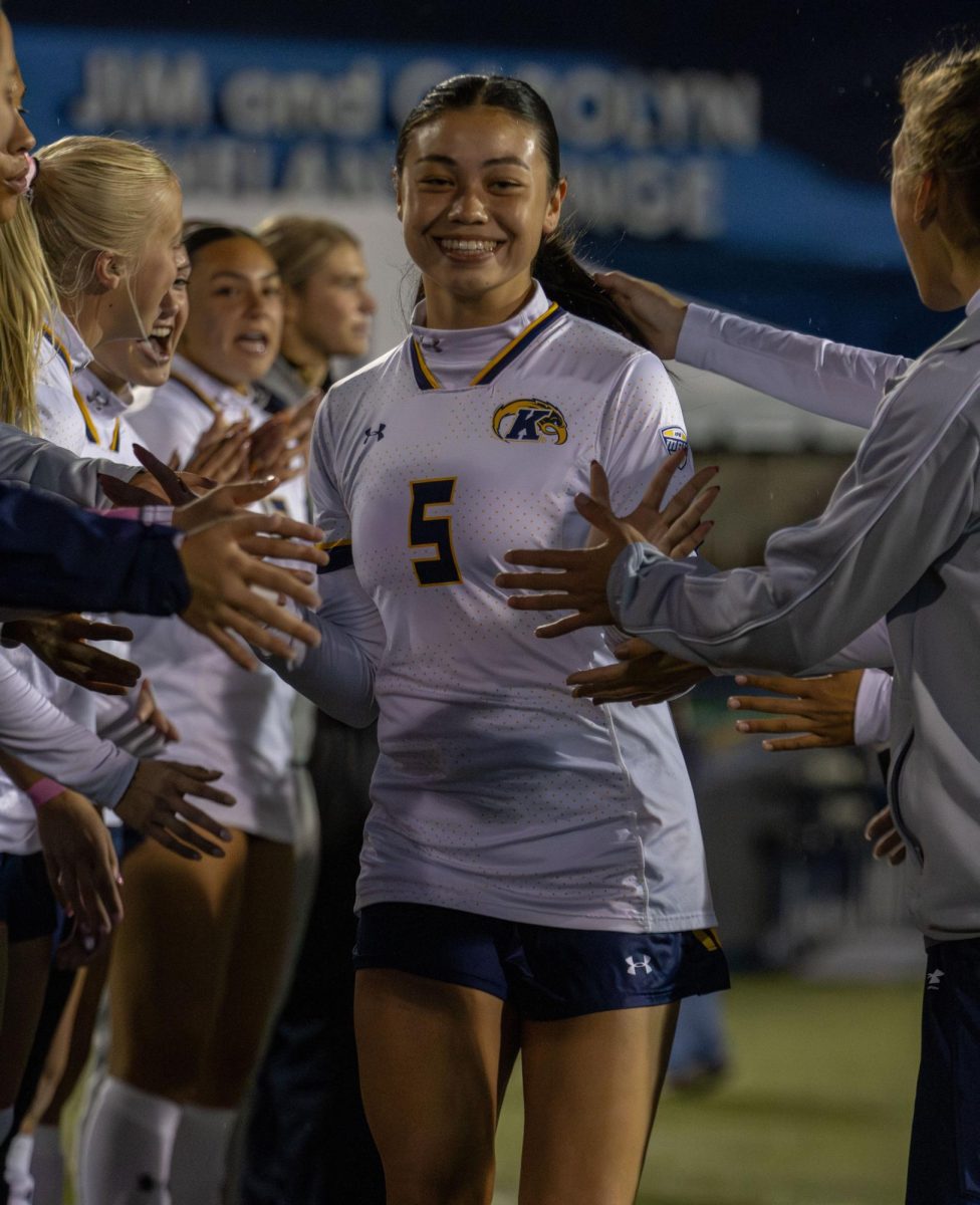 Kent junior forward, Kiyomi McCausland, high fives her teammates as she runs through the tunnel during the player introduction before their match against Toledo on Thursday, Oct. 23, 2025.