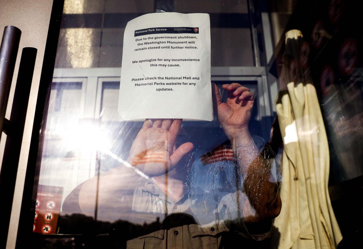 A member of the U.S. Park Service puts up a closed sign at the Washington Monument on October 1 in Washington, DC.