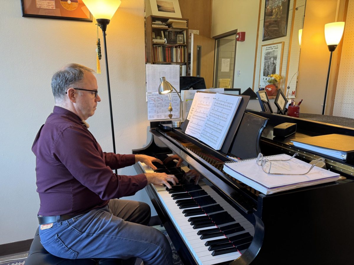 Jay White, professor of voice in the School of Music at Kent State, plays his piano in his office. 