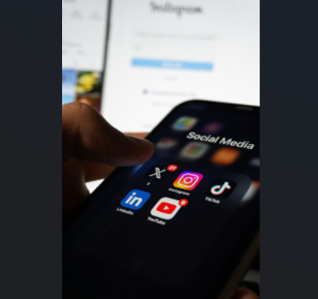 Teenagers open the social media app folder on their phone.