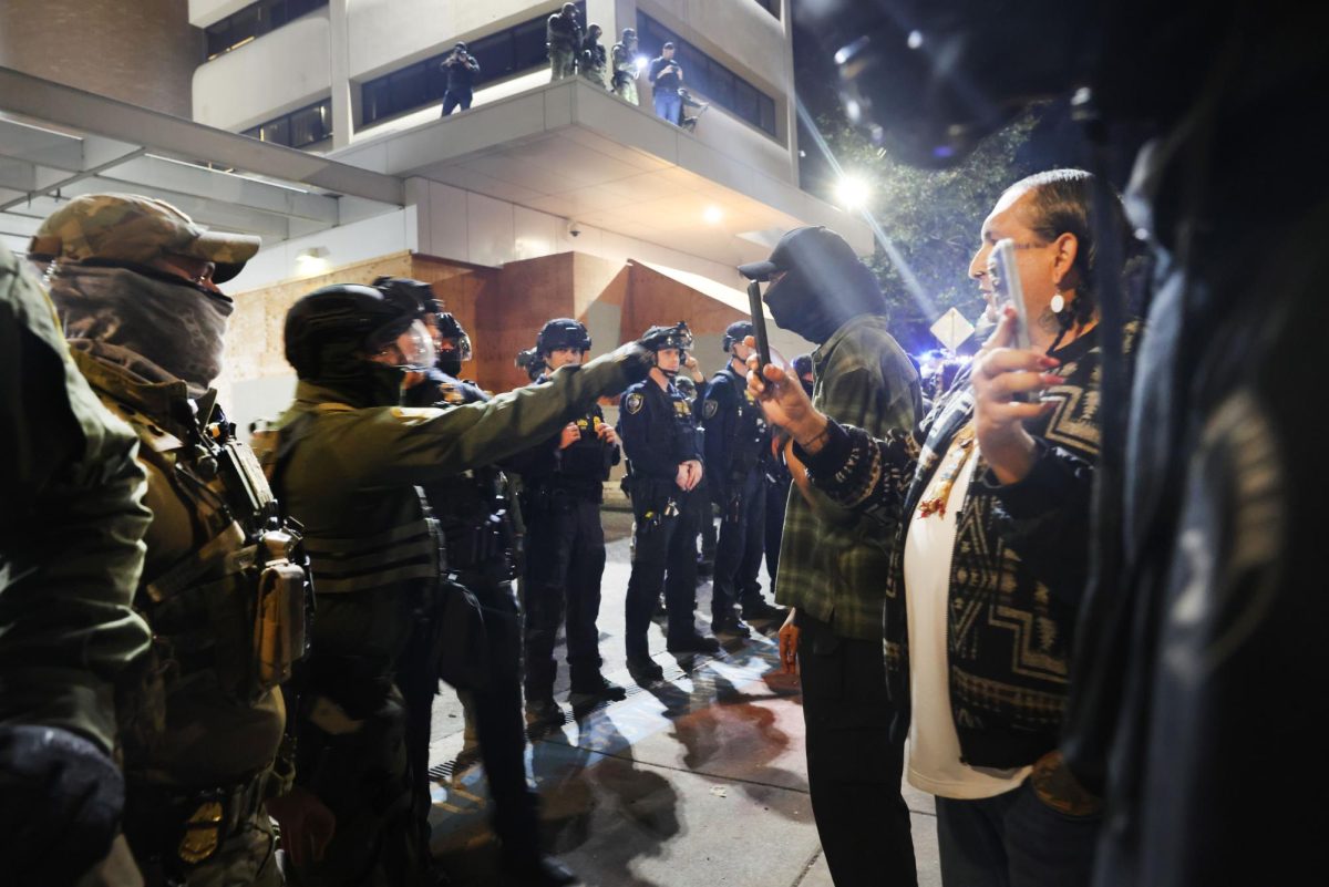 Federal agents, including members of the Department of Homeland Security, and the Border Patrol, hold back protesters outside a downtown U.S. Immigration and Customs Enforcement (ICE) facility.