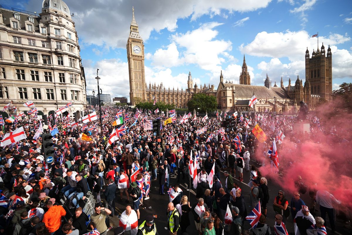 Anti-immigration protesters wave British and England flags during the "Unite The Kingdom" rally in London on September 13, 2025.