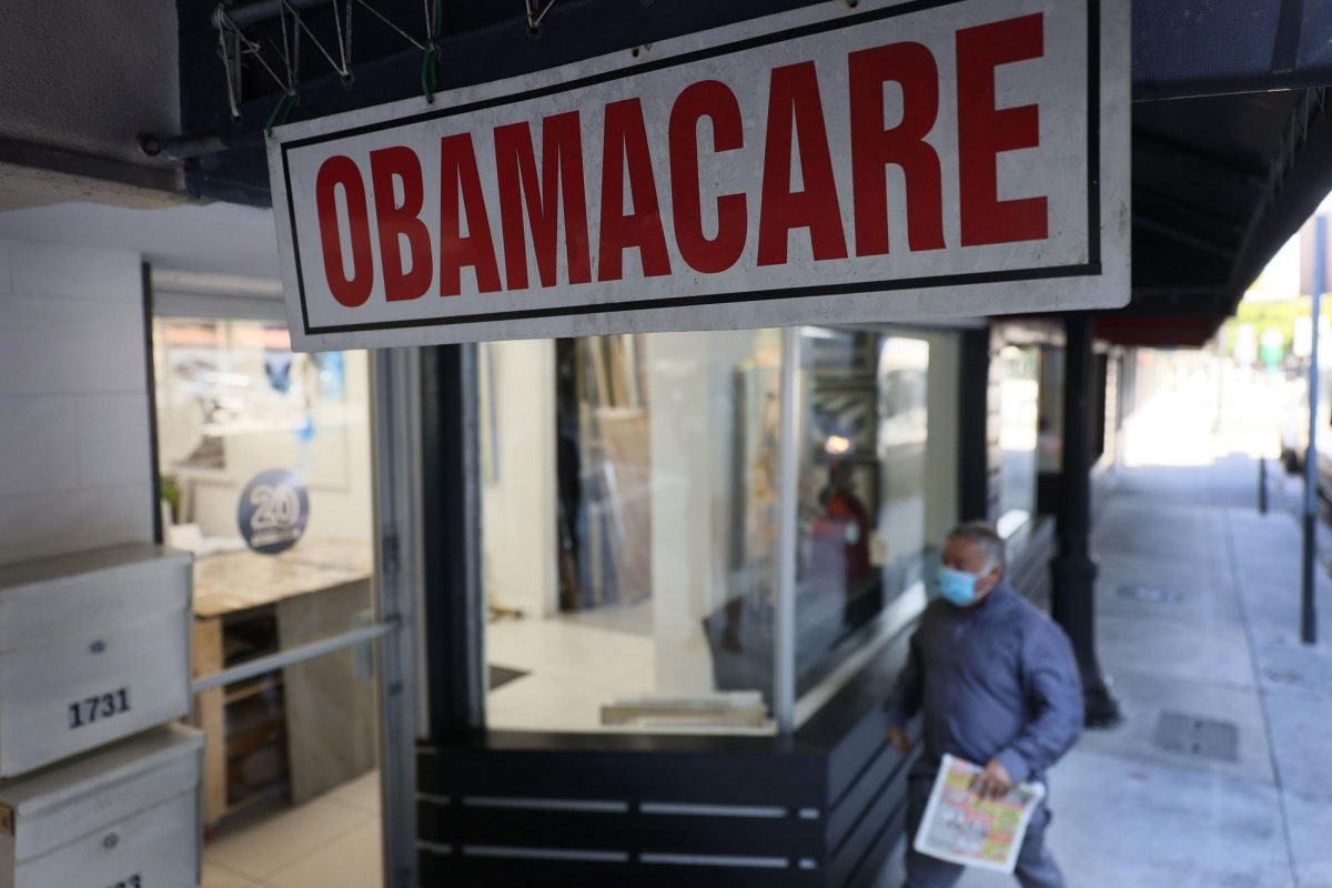 A pedestrian walks past the Leading Insurance Agency, which offers plans under the Affordable Care Act (also known as Obamacare) on January 28, 2021, in Miami, Florida.