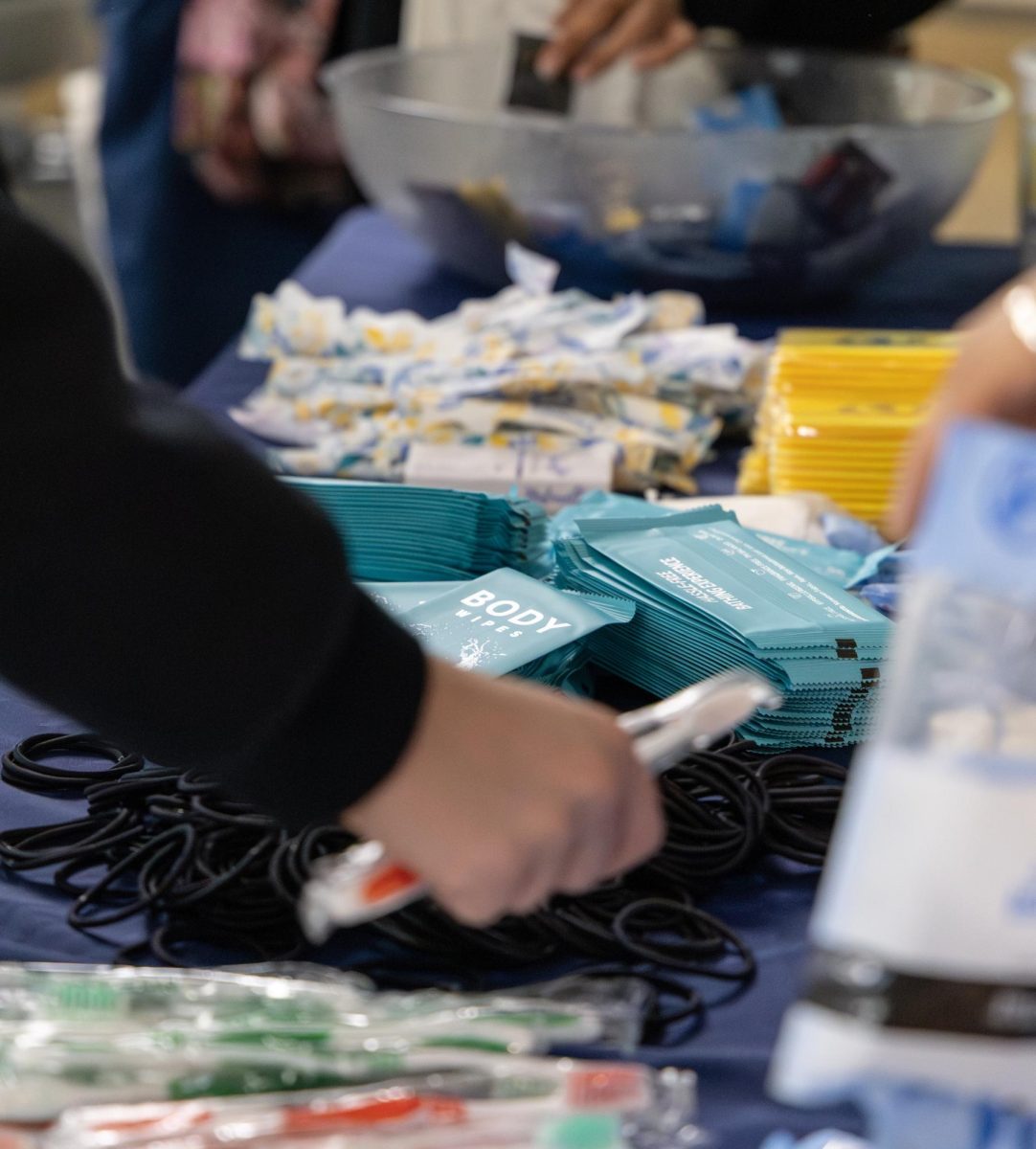 An attendee picks up a free hair tie that is offered as one of the items to build your own self care kit during the event for sex week on Tuesday, Nov. 18, 2025.