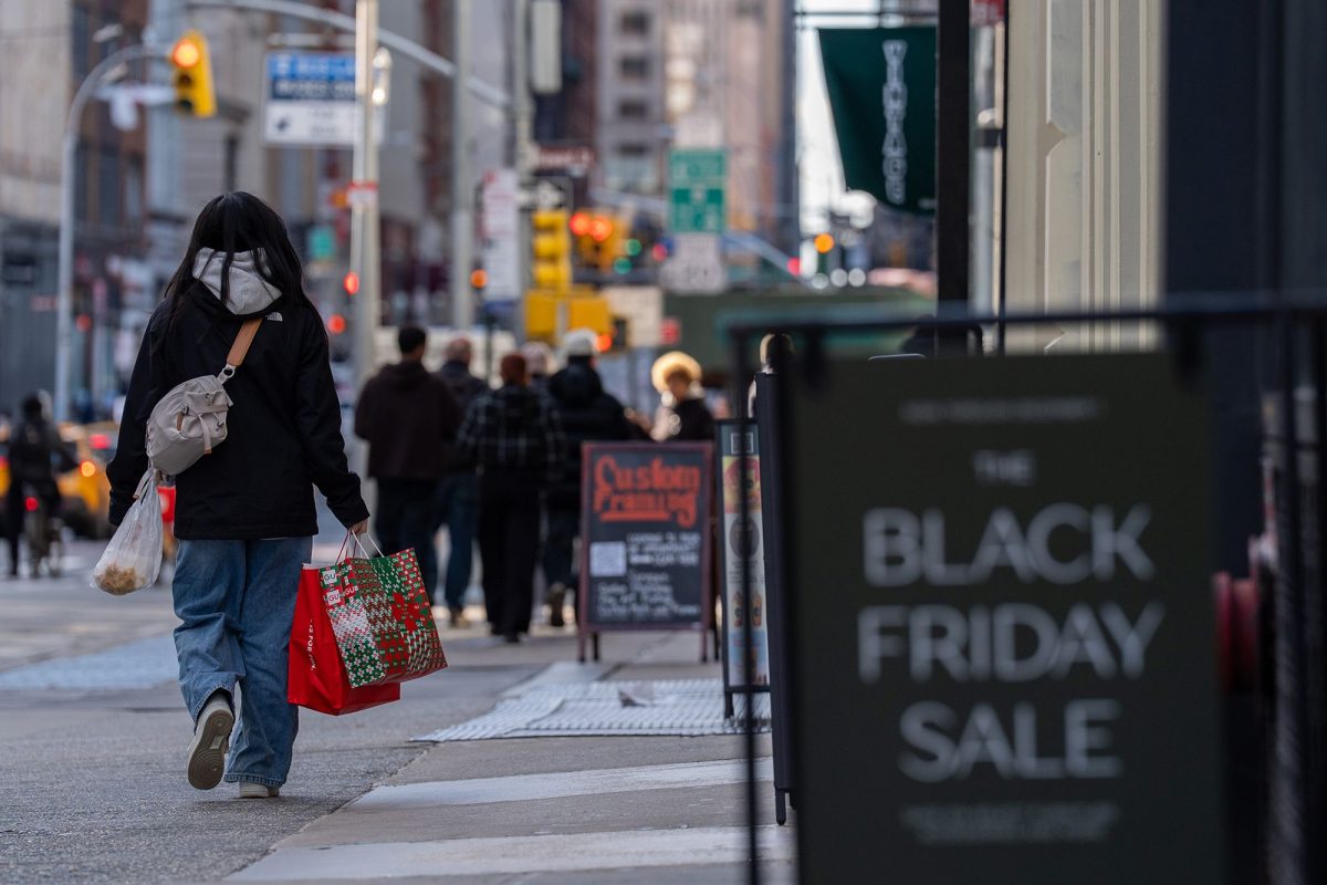 A shopper carries bags on Black Friday in the Soho neighborhood of New York, on November 28, 2025.