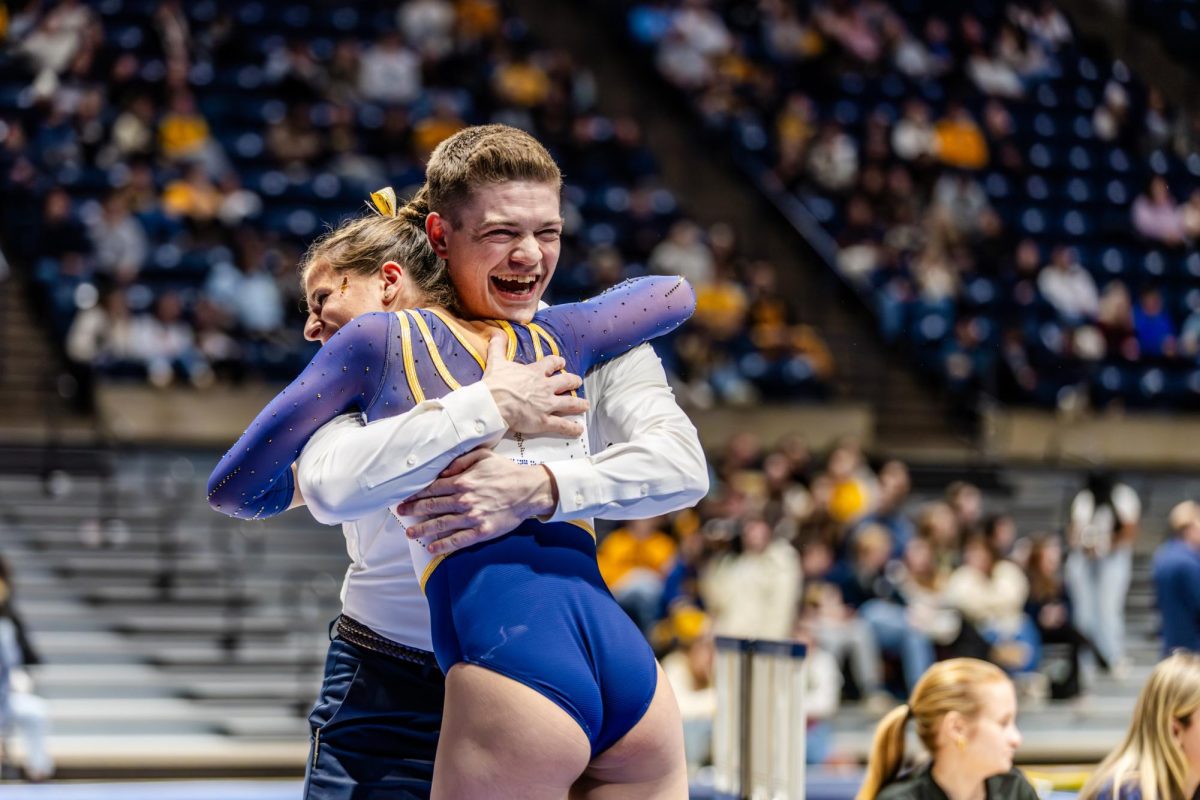 Kent senior Zoe Rankin celebrates with her coach Tim Levandowski as they compete at the West Virginia meet on Friday Jan. 30, 2026.