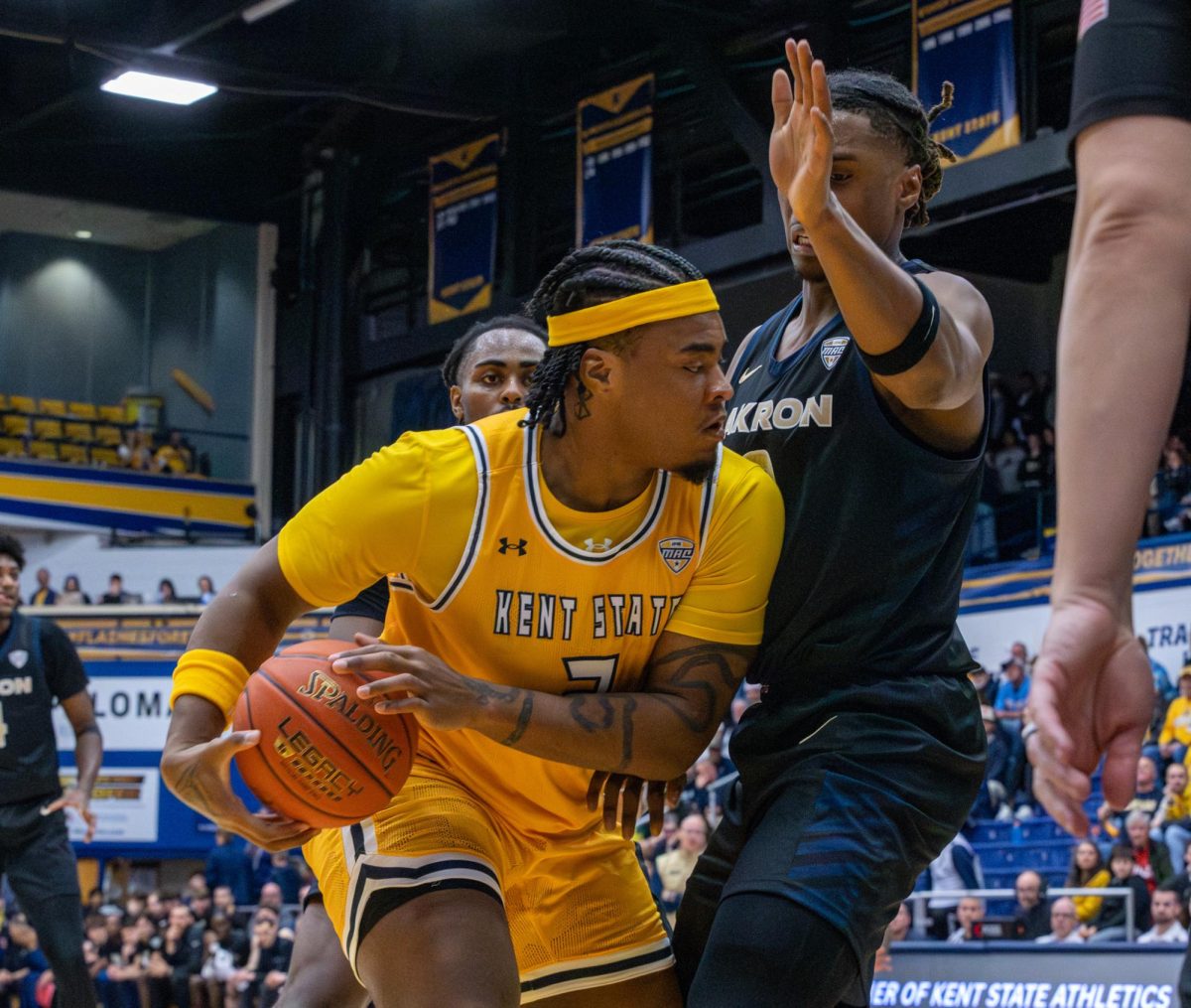 Kent graduate student Rob Whaley holds the ball as Akron senior Amani Lyles tries to block him during the second half of their game on Feb. 27, 2026.