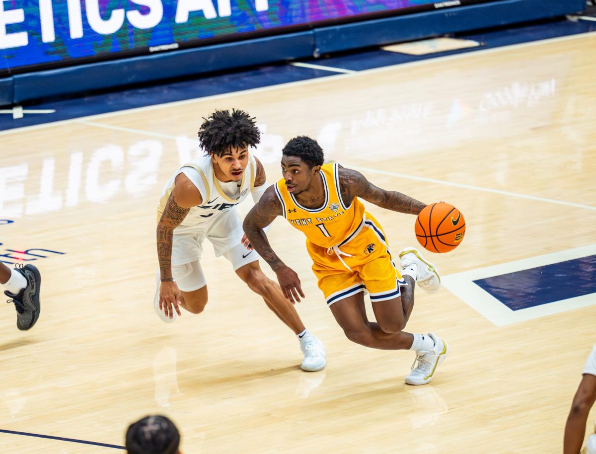 Kent junior Cian Medly dribbles up court while Akron sophomore Sharron Young defends him during the first half of their game on Jan. 30, 2026.