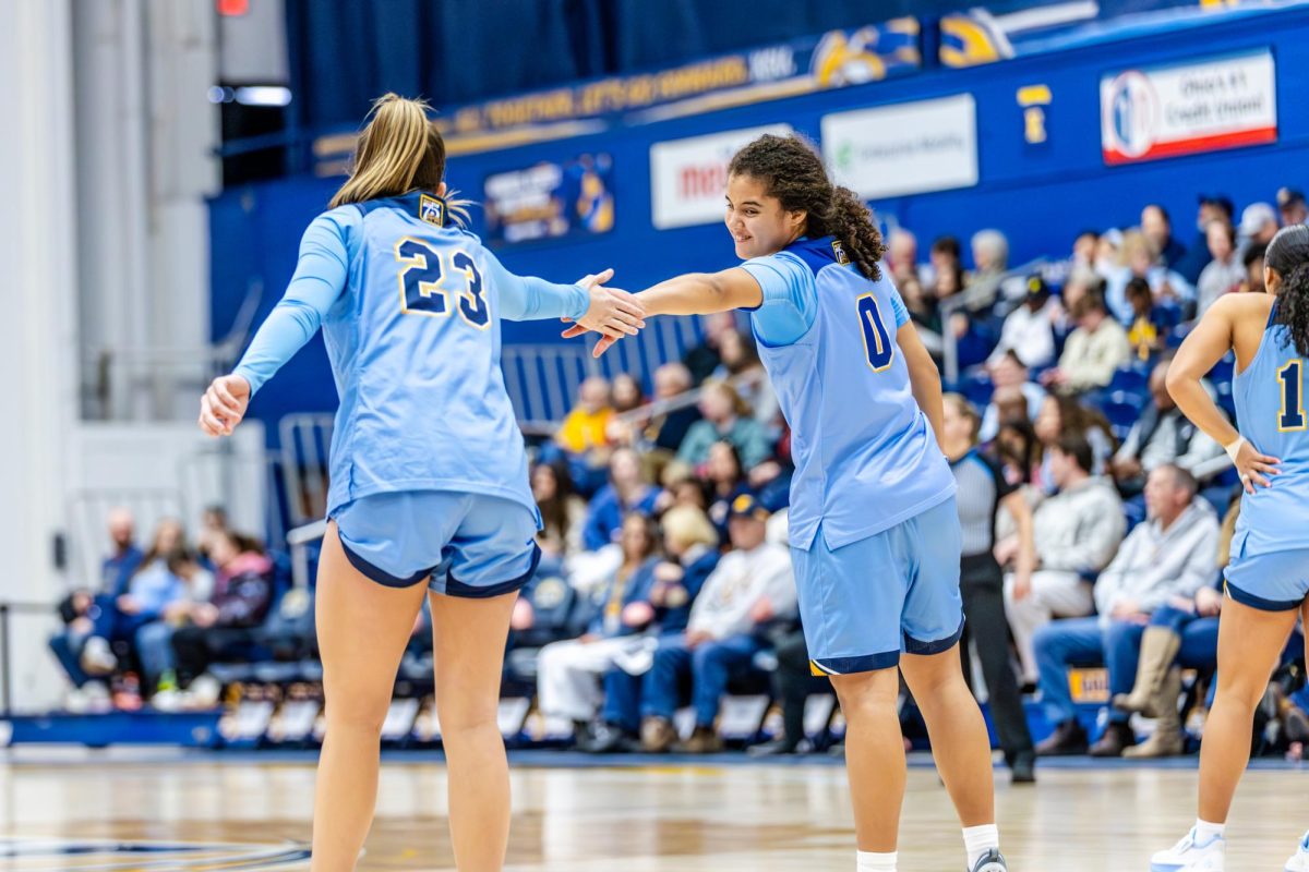 Kent junior Mya Babbitt, 23, high fives freshman Caitlyn Holmes, 0, early in the second half against Ball State on Saturday Feb. 1, 2026.