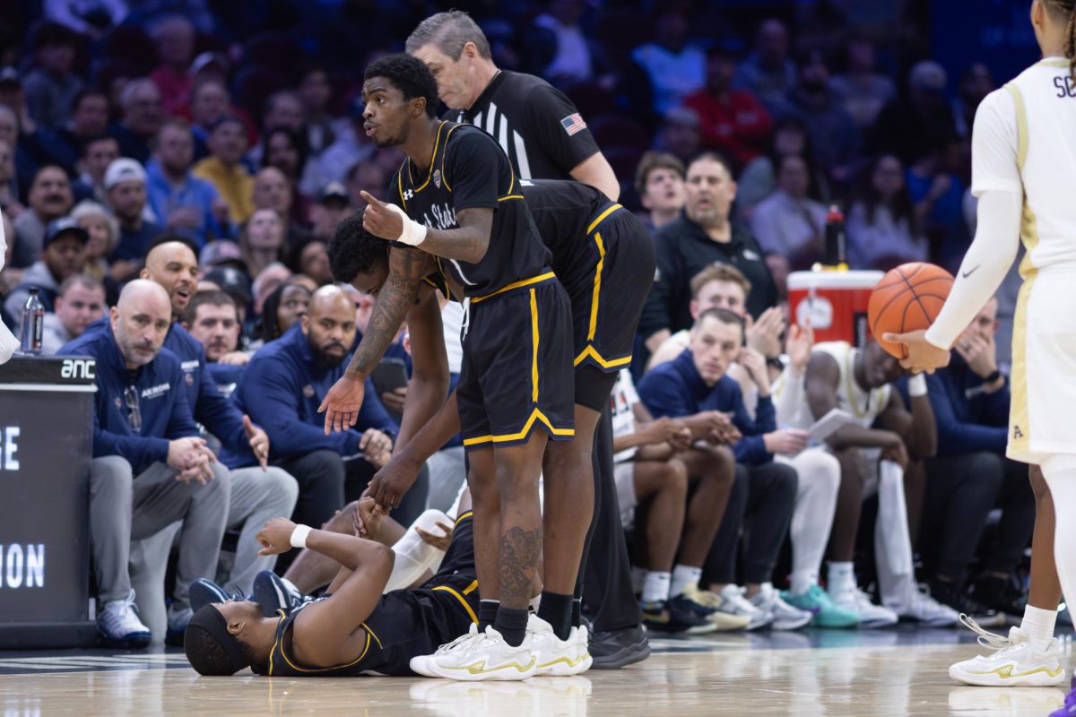 Kent players Cian Medley and Delrecco Gillespie help teammate Jahari Williamson off the court after a foul call during the Semifinal round against the University of Akron on March 13, 2026.