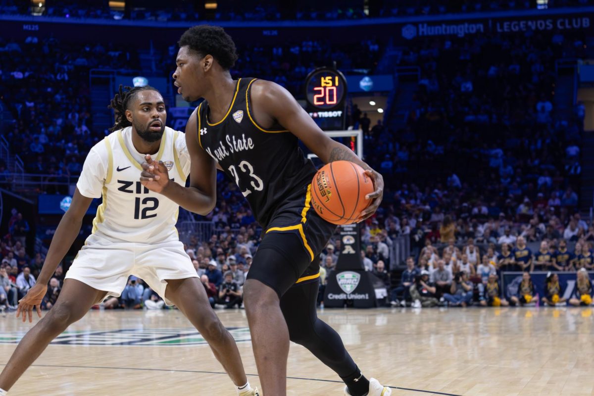 Kent's Delrecco Gillespie attempts to move past Akron defender Evan Mahaffey to try and score a basket in the first half of the Mid-American Conference Tournament Semifinal on March 13, 2026.