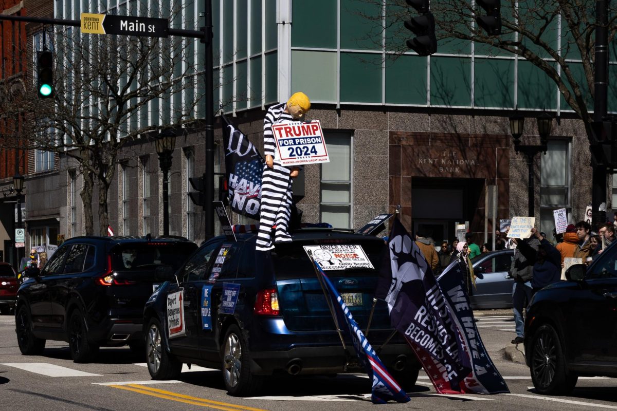 A car drives through Main street and honks at protestors in support of the No Kings Protest on March 28, 2026. 
